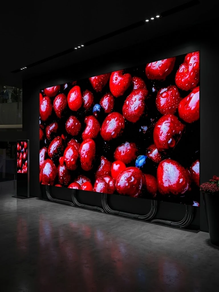 Große Indoor-LED-Wand mit roten Kirschen in einem dunklen Showroom