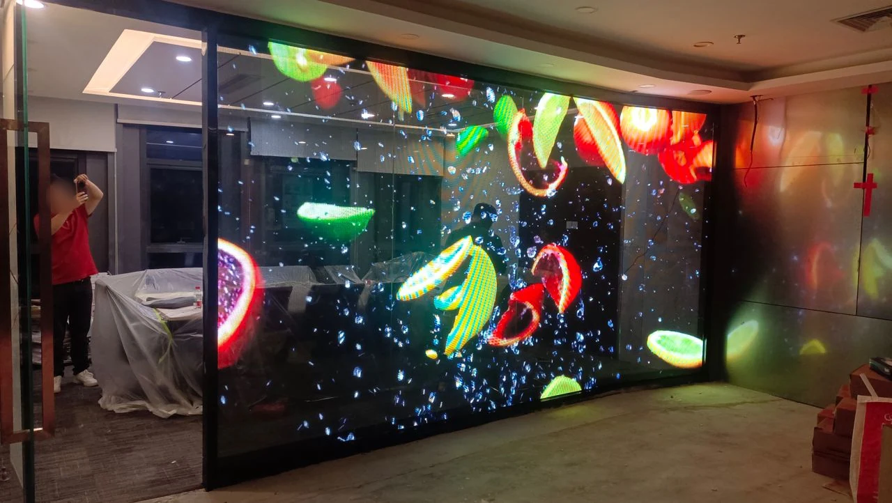 Transparente LED-Glaswand mit Früchten und Wassertropfen in einem Büro